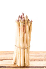 White asparagus bundle on wooden surface, with white background
