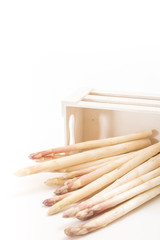 Bunch of white asparagus spears in a box, on white background and copy-space