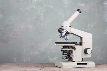Microscope on table on green background