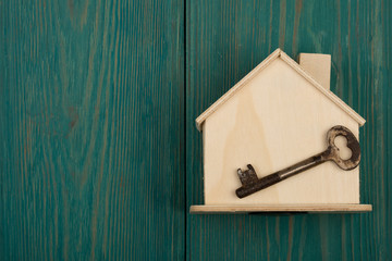 little blank house and key on blue wooden desk