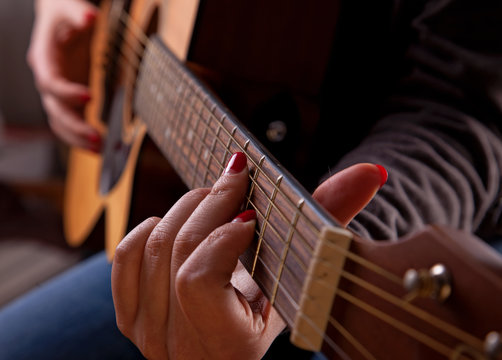 Close-up of woman playing acoustic guitar