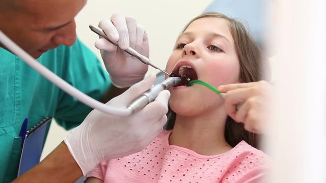 Cute young girl having her teeth fixed at the dentist's