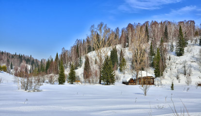 Snow covered cabin in the mountains valley
