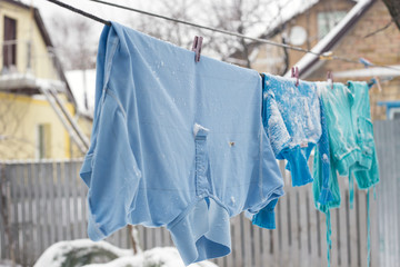 frozen underwear on the street in winter. Snow on the washed linen
