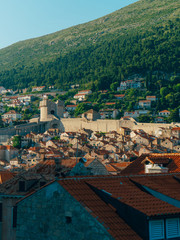 Fototapeta na wymiar Dubrovnik Old Town, Croatia. Tiled roofs of houses. Church in the city. City View from the wall.