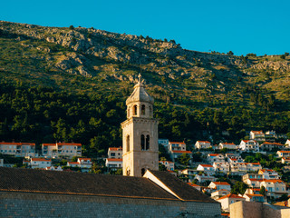 Fototapeta na wymiar Dubrovnik Old Town, Croatia. Tiled roofs of houses. Church in the city. City View from the wall.