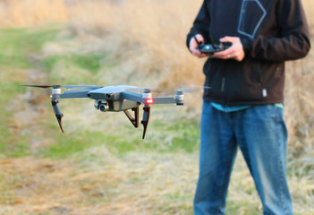  Unidentified man piloting  drone quadrocopter with high resolution camera.