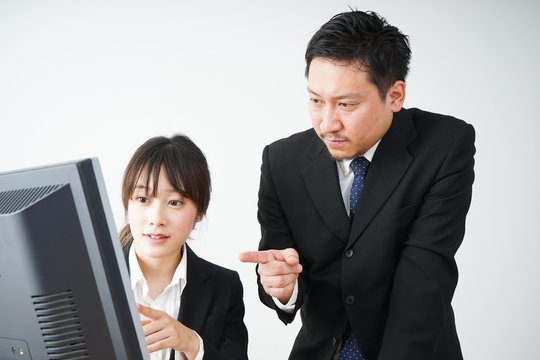 若いビジネスウーマンと指導をする上司の男性