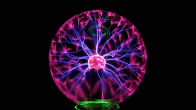 Plasma Ball And Lightning. High voltage. Tesla generator. Close-up view of plasma ball with moving energy rays inside on black background. Electric ball on the black background.