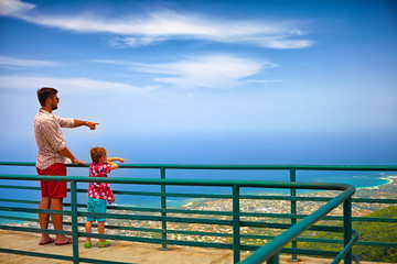 happy father and son, tourists enjoying the fascinating view on Atlantic ocean coastline from...