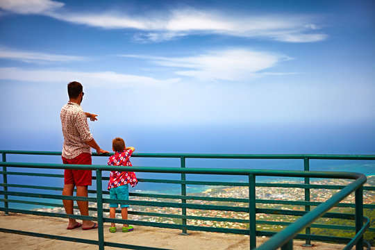 happy father and son, tourists enjoying the fascinating view on Atlantic ocean coastline from observation deck of Pico Isabel de Torres