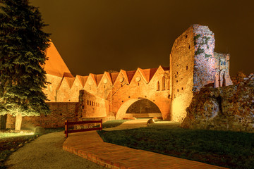 Naklejka premium Teutonic Knights castle ruins illuminated at night in Old Town of Torun. Poland, Europe. 