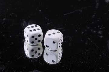 Old bone dice on damaged mirror background