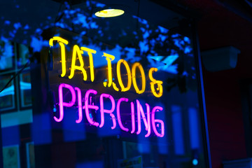 Neon Tatoo and Piercing Sign at Night