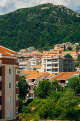 Fototapeta na wymiar New homes in Budva, Montenegro. New town. Real estate on the shores of the Adriatic Sea. House with orange roof tiles