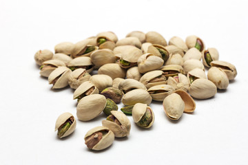 A close up shot of pistachios on white background.