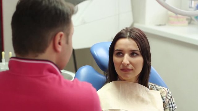 dentist carries on a conversation with the patient