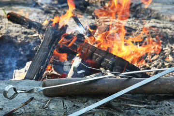 Skewers with an ax near the fire in the spring