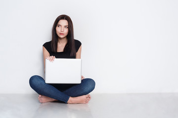 Woman using laptop sitting on the studio floor