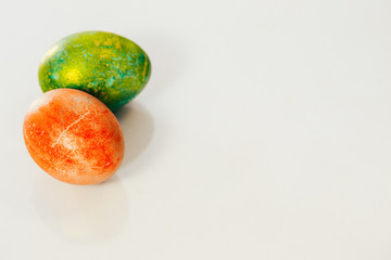 Red and green Easter eggs on white background.