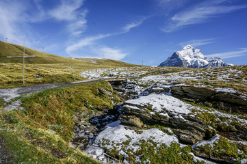 Wide angle of wooden bridge with green glass and snow mountains in Switzerland