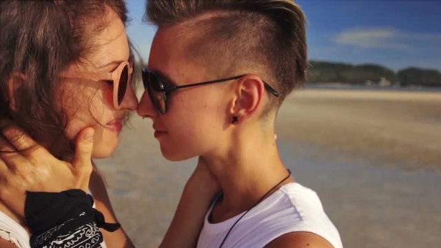 Young lesbian couple embracing together on the beach