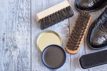   Shoes and care products for footwear on a gray wooden floor.