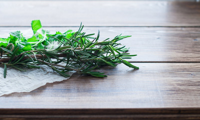 Seasonings, rosemary and mint on a wooden table. Ingredients for cooking, culinary spices