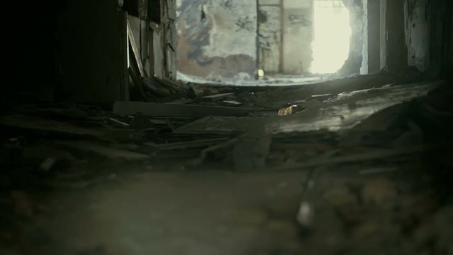 Gimbal steadicam pov shot of someone exploring the corridors and rooms of a huge demolished abandoned building.