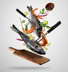 Foto auf Acrylglas Fish Fliegende rohe ganze Brassen und Garnelen mit Zutaten