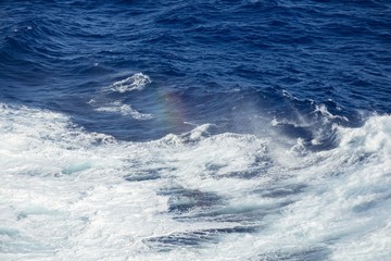 Spray rainbow from deep ocean waves