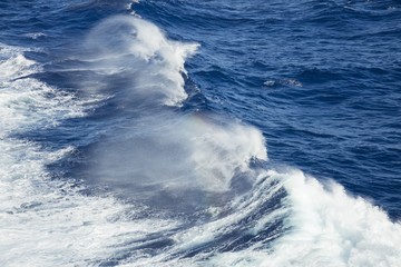 Spray rainbow from the deep ocean waves
