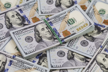 Background of dollar bills and a bundle of dollars on top