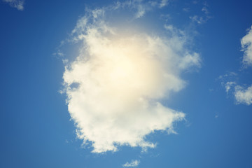 Sun and clouds against a blue sky