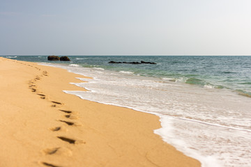 Foot prints in the golden sand beach.