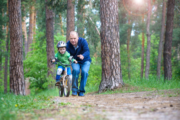 Obraz premium Little kid boy of 3 years and his father in autumn forest with a