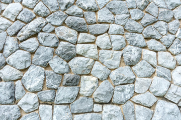 Background wall made of stones held together with cement. Wall made of stones close-up