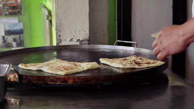 Man cooks fried Indian bread roti

