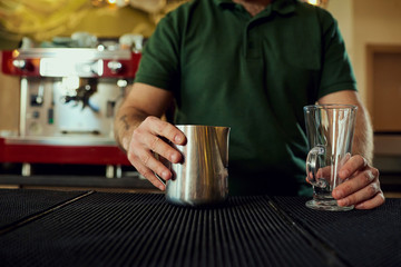 Fototapeta na wymiar The bartender barista with a glass in bar cafe restaurant.