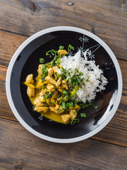 Delicious turkey mango curry with rice on a black plate