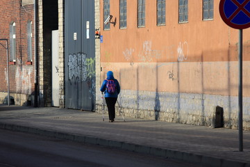 Starsza kobieta uprawia nordic walking, spacer.