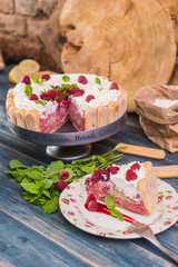 Homemade cake with biscuit and raspberries on wooden background