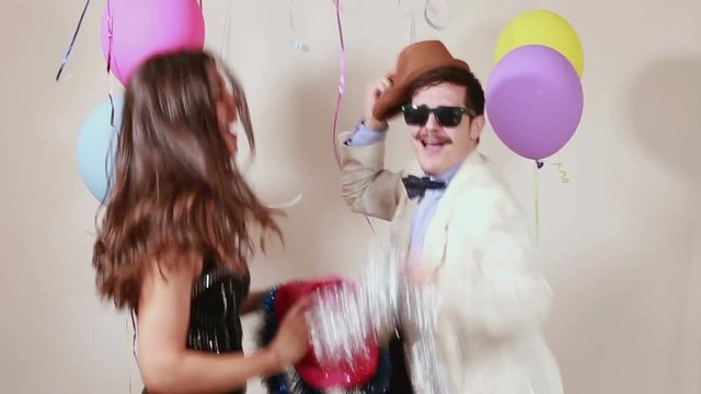 Sexy woman and handsome man having awesome time dancing in party photo booth