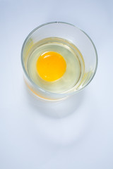 Raw chicken egg in glass bowl isolated on white background