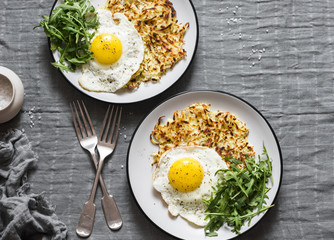 Potato latkes , fried egg and arugula on grey background, top view. Delicious simple lunch