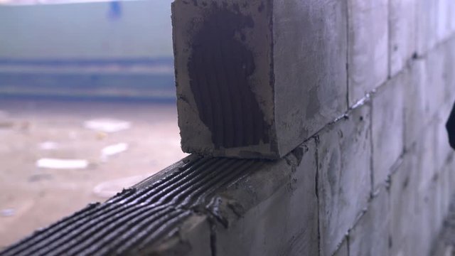 Worker building a wall of aerated concrete blocks