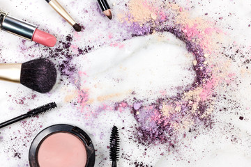 Makeup brushes, lipstick etc forming frame for copyspace