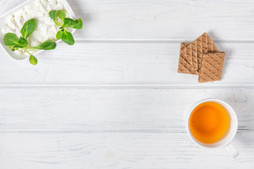 Herbal tea, cheese and waffles on the table. Copyspace for text.