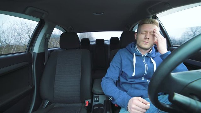 Tired young driver sitting in the car and lighting a cigarette in 4K