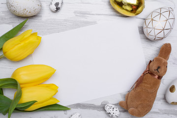 Easter eggs and tulips over wooden background.